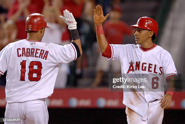 Orlando Cabrera of the Los Angeles Angels of Anaheim is congratulated by Maicer Izturis after a two-run home run in the fourth inning of 10-5 victory...