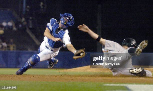 Todd Helton of the Colorado Rockies eludes tag of Los Angeles Dodgers catcher Brett Mayne to slide safety into home plate for the go-ahead run in the...