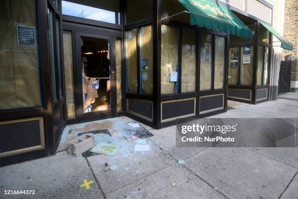 Broken bottle and glass lays in front of a state-owned wine and liquor store after it is vandalized overnight, in the Mt Airy neighborhood in...