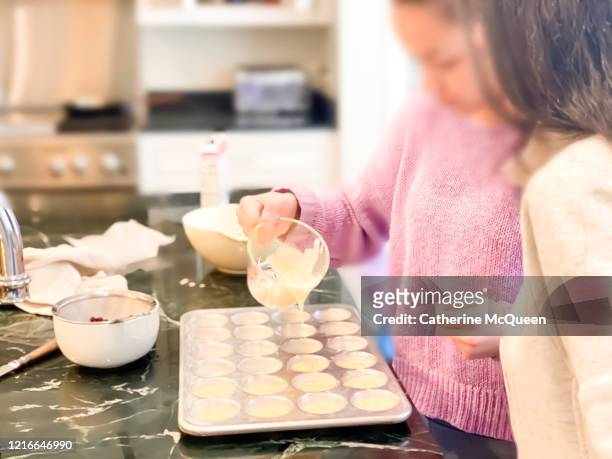 mixed-race teen sisters baking muffins at home - girl baking stock pictures, royalty-free photos & images