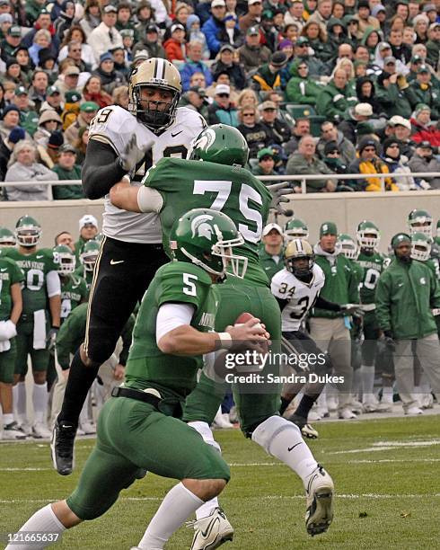 S Drew Stanton tucks the ball and runs as Purdue's Anthony Spencer closes in during the 2nd quarter in the Purdue win over Michigan State, 17-15 at...