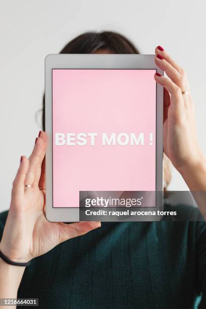 young woman holding a digital tablet with the message " best mom " with pink background - composizione verticale foto e immagini stock