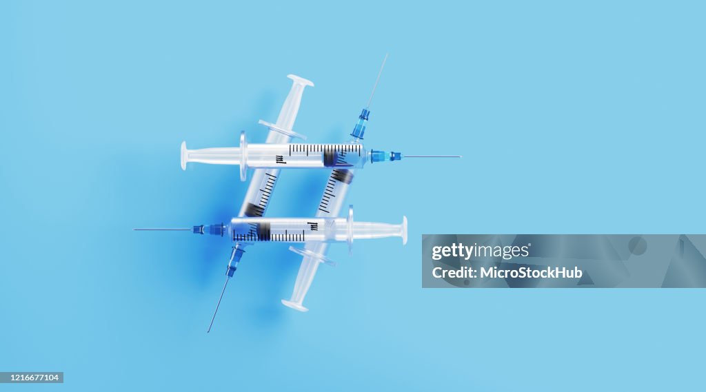 Syringes Forming A Hashtag Symbol on Blue Background