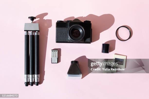 top view of retro analog photo equipment on pink background - tripod stock-fotos und bilder