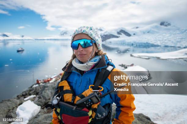 portrait of a polar guide on shore above a glaciated bay and snow capped mountains - polar climate stock pictures, royalty-free photos & images