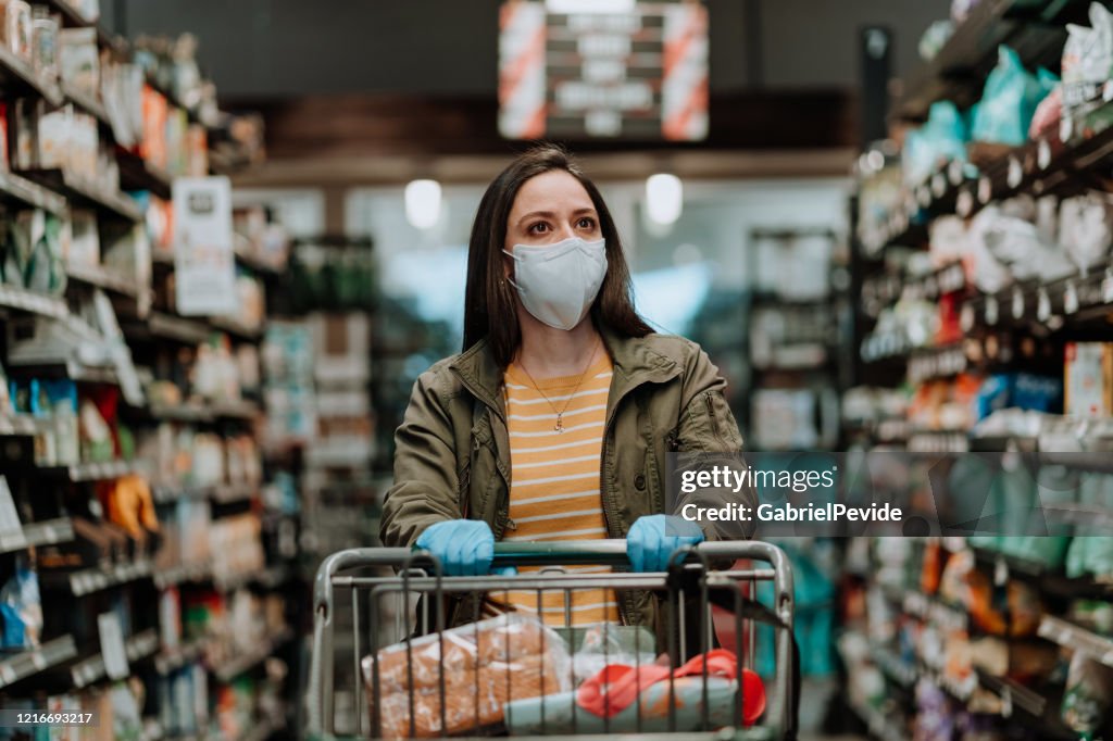 Vrouw die supermarktkar tijdens COVID-19 duwt