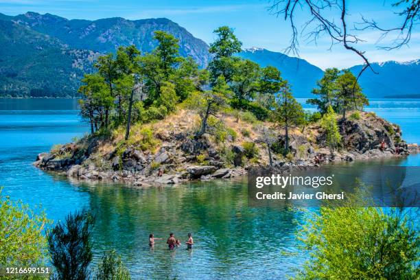 panoramic view of "la islita" and people bathing in lake lácar. san martín de los andes, neuquén, argentina. - argentinien island stock pictures, royalty-free photos & images