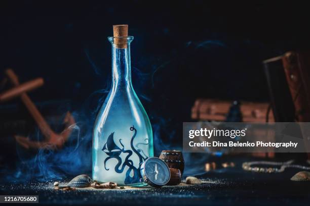 sea monster, kraken inside a glass bottle, magical travel still life with copy space - kraken bildbanksfoton och bilder