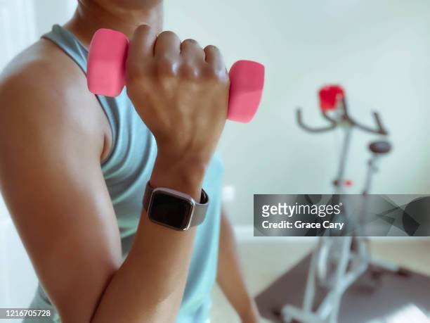 woman holds lightweight dumbbell - womens hand weights stock pictures, royalty-free photos & images