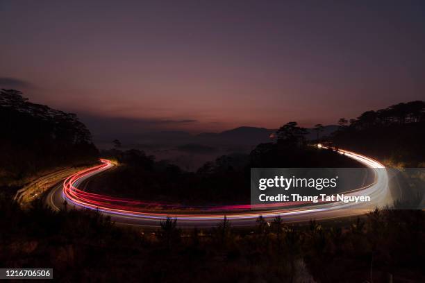 traffic light on pass road - long exposure light trails stock pictures, royalty-free photos & images