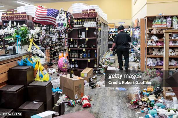 Santa Monica, CA, Sunday May 31, 2020 - A police officer inspects the damage to a Vons supermarket hours after it was looted.