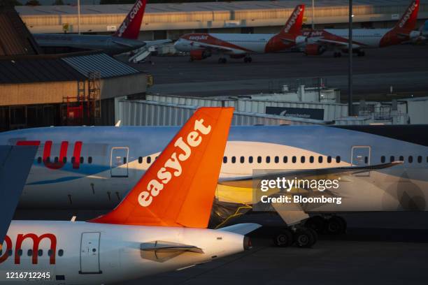 Passenger aircraft, operated by Easyjet Plc and Tui AG, stand grounded on the tarmac at Manchester Airport, operated by Manchester Airport Plc, in...