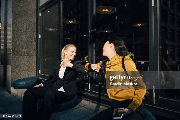 women greeting using elbows - elbow bump stock pictures, royalty-free photos & images