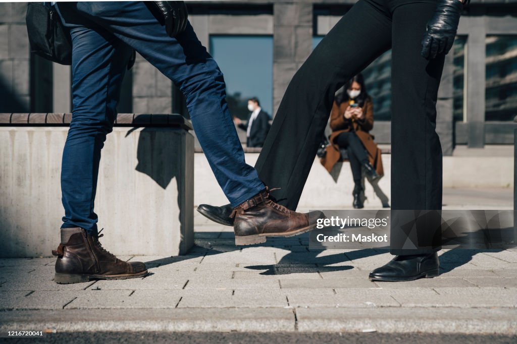 Two people greeting with feet during pandemic