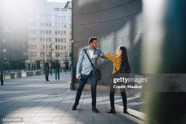 man and woman greeting with elbows - abstand halten infektionsvermeidung stock-fotos und bilder