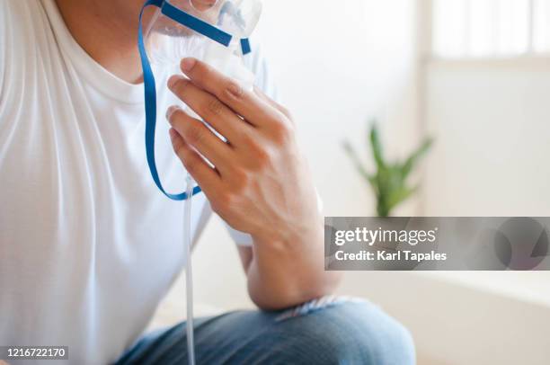 a young southeast asian man is using a breathing and respiratory equipment - copd stock pictures, royalty-free photos & images