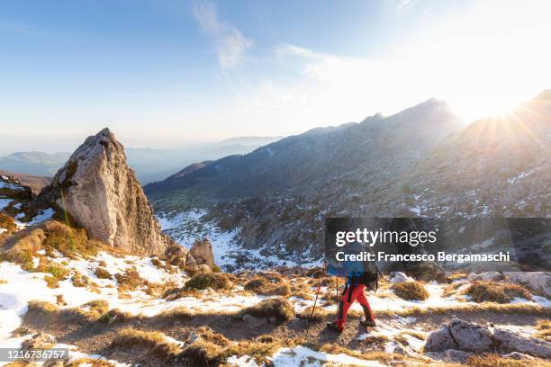 young hiker walks on sunlit path in the mountain. - bergamo stock photos et images de collection