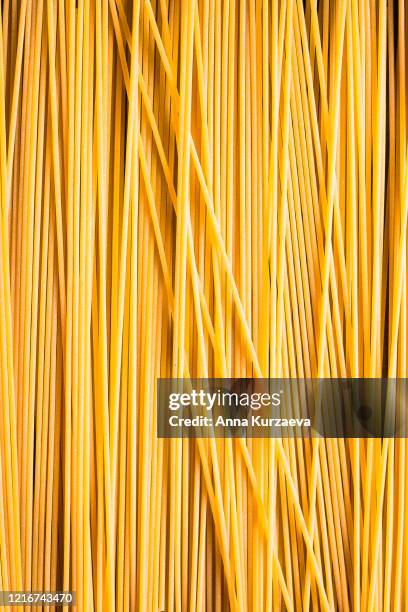 heap of uncooked whole wheat spaghetti italian pasta, top view. pasta pattern. food background. - espaguete fotografías e imágenes de stock