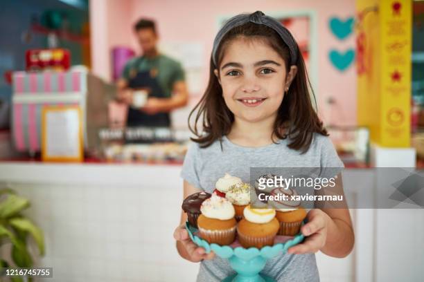 junge mädchen holding dessert stand von gourmet cupcakes - cupcakes girls stock-fotos und bilder