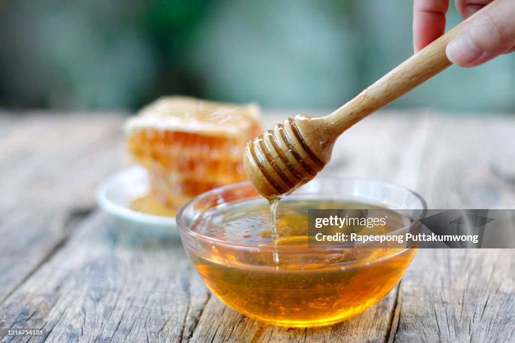 Honey dipper and honeycomb on table