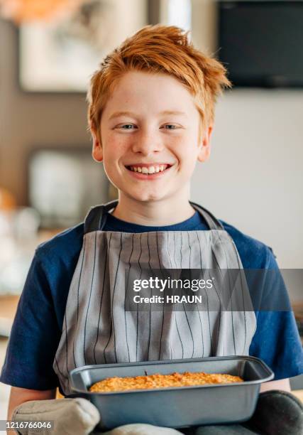 young boy holding warm freshly baked bread at home - apron isolated stock pictures, royalty-free photos & images