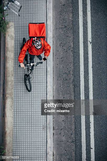 food delivery man with bicycle on city footpath - buenos aires food stock pictures, royalty-free photos & images