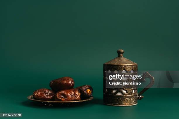 turkish metal coffee cup with lid and saucer with dates - religiöse opfergabe stock-fotos und bilder