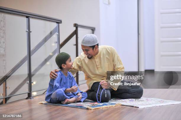 adoración de la familia musulmana durante el ramadán - niños orando fotografías e imágenes de stock