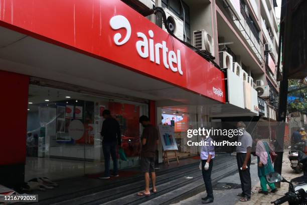 Customer maintain social distance at the outside Airtel store after the local government eased restrictions imposed as a preventive measure against...