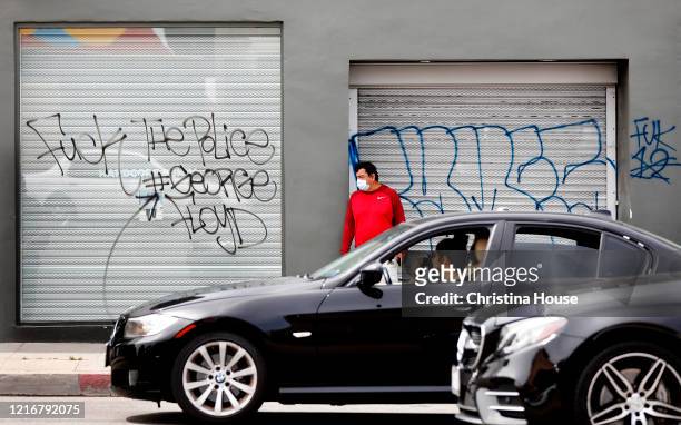 Traffic builds on Melrose Avenue to view the Graffiti and shattered storefronts on Sunday, May 31, 2020.