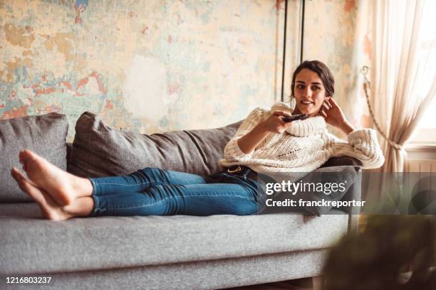 mujer en casa viendo la televisión durante el cierre - telerrealidad fotografías e imágenes de stock