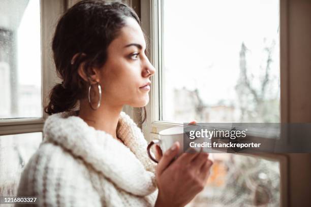 sad woman at home for the corona virus - winter sadness stock pictures, royalty-free photos & images