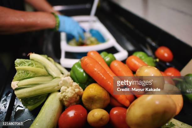 cropped hands wearing protective gloves disinfecting groceries - food waste stockfoto's en -beelden