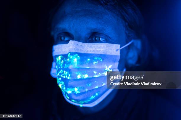 uomo che indossa una maschera protettiva per il viso - luce ultravioletta foto e immagini stock