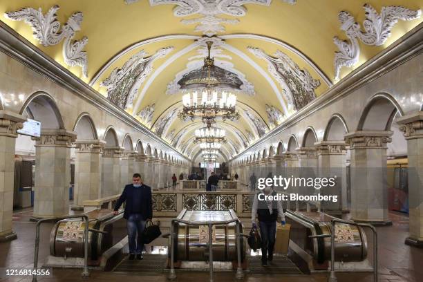 Passengers wearing protective face masks alight an escalator inside a Moscow Metro train station in Moscow, Russia, on Monday, June 1, 2020....