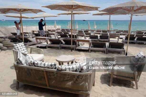 Employees prepare the terrace of a restaurant on the beach of the French Riviera city of Ramatuelle, southern France, on June 1 as France eases...