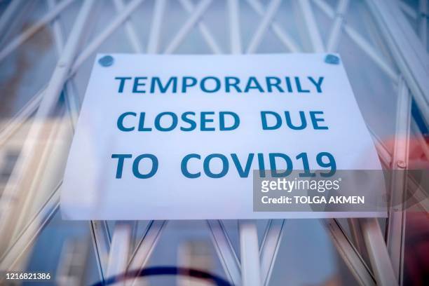 Sign is seen in the window of a shop explaining to customers that it has temporarily closed due to the coronavirus outbreak in Portobello Market in...