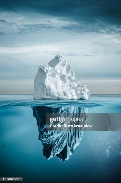 eisberg mit ober- und unterwasser - iceberg stock-fotos und bilder