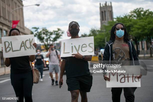 Protesters march with three placards stating "BLACK Lives Matter" in the aftermath of widespread unrest following the death of George Floyd on June...