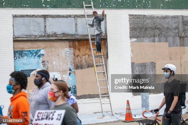 Painter atop a ladder addresses protesters marching in the aftermath of widespread unrest following the death of George Floyd on June 1, 2020 in...