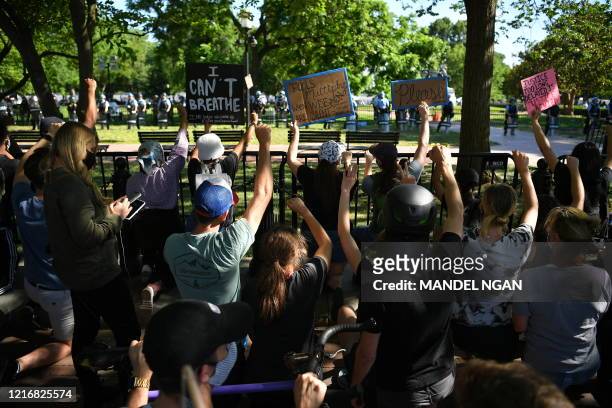 Protestors take a knee and raise their fists in Lafayette Square near the White House in Washington, DC on June 1, 2020. Police fired tear gas...