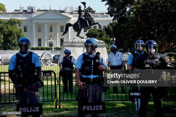 Police officers hold a perimeter near the White House as demonstrators gather to protest the killing of George Floyd on June 1, 2020 in Washington,...