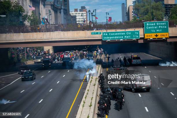 Police officers throw and shoot tear gas into a group of protesters after a march through Center City on June 1, 2020 in Philadelphia, Pennsylvania....