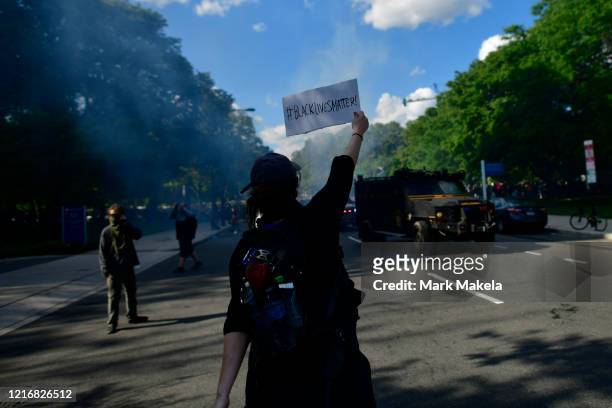 Protester holds a sign stating "BLACK LIVES MATTER" towards police shooting tear gas after a march through Center City on June 1, 2020 in...