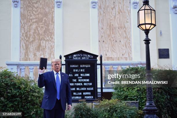 President Donald Trump holds up a Bible outside of St John's Episcopal church across Lafayette Park in Washington, DC on June 1, 2020. - US President...