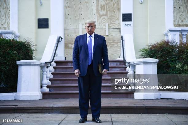 President Donald Trump holds up a bible in front of boarded up St John's Episcopal church after walking across Lafayette Park from the White House in...