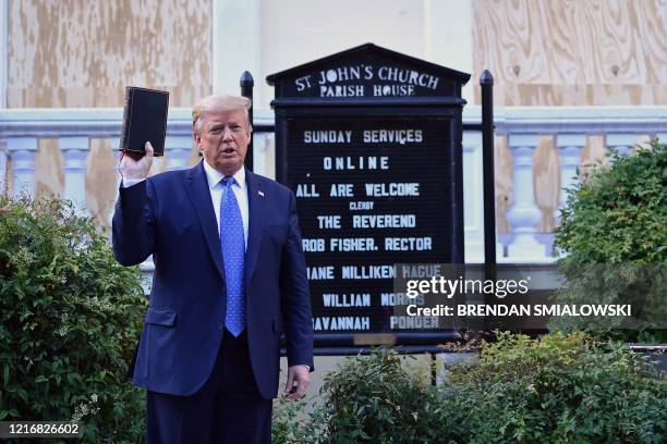 President Donald Trump holds up a Bible outside of St John's Episcopal church across Lafayette Park in Washington, DC on June 1, 2020. - US President...