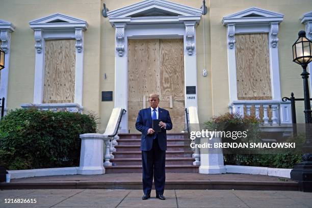 President Donald Trump holds up a Bible outside of St John's Episcopal church across Lafayette Park in Washington, DC on June 1, 2020. - US President...