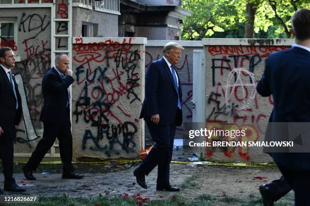 President Donald Trump walks back to the White House escorted by the Secret Service after appearing outside of St John's Episcopal church across...