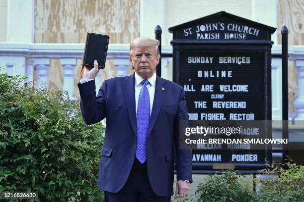 President Donald Trump holds up a Bible outside of St John's Episcopal church across Lafayette Park in Washington, DC on June 1, 2020. - US President...